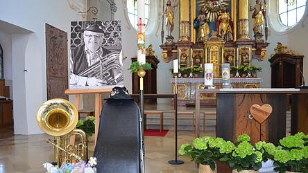 Seine Tuba und Blumengr&uuml;&szlig;e der Grundschule erg&auml;nzten das Bild des verstorbenen Josef (Sepp) Lehner beim Gottesdienst in der Kirche.
