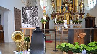 Seine Tuba und Blumengr&uuml;&szlig;e der Grundschule erg&auml;nzten das Bild des verstorbenen Josef (Sepp) Lehner beim Gottesdienst in der Kirche.