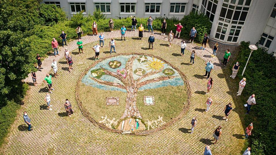 Dank kräftiger Wurzeln wächst an den Ästen eine gute Ernte: Das überdimensionale Kunstwerk im Innenhof der Klinik, umgeben von Rehabilitanden und Mitarbeitern. Dank kräftiger Wurzeln wächst an den Ästen eine gute Ernte: Das überdimensionale Kunstwerk im Innenhof der Klinik, umgeben von Rehabilitanden und Mitarbeitern.
