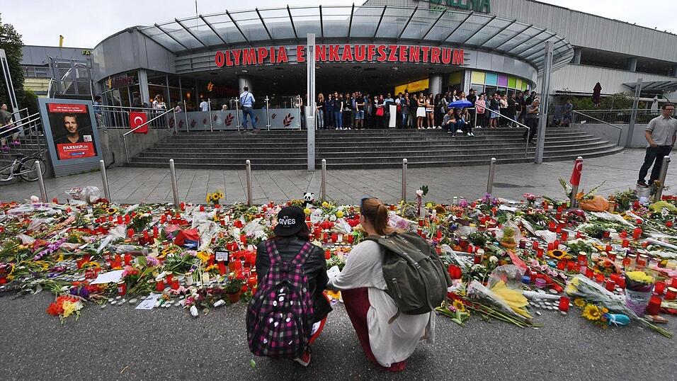 Blumen und Kerzen liegen Ende Juli 2016 vor dem Haupteingang des Olympia-Einkaufszentrums (OEZ). Drei Tage zuvor hatte dort ein 18-Jähriger neun Menschen erschossen und sich danach selbst getötet. (Archiv) Blumen und Kerzen liegen Ende Juli 2016 vor dem Haupteingang des Olympia-Einkaufszentrums (OEZ). Drei Tage zuvor hatte dort ein 18-Jähriger neun Menschen erschossen und sich danach selbst getötet. (Archiv)