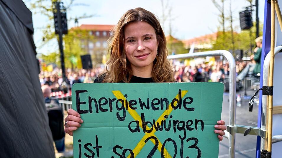 Luisa Neubauer h&auml;lt ein Schild mit der Aufschrift &laquo;Energiewende abw&uuml;rgen ist so 2013&raquo; in der Hand.