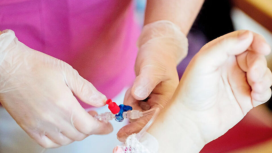 Ein Pfleger schließt einem Patienten eine Infusion an. In Kliniken wird der Personalmangel zu einem immer größeren Problem. Ein Pfleger schließt einem Patienten eine Infusion an. In Kliniken wird der Personalmangel zu einem immer größeren Problem.