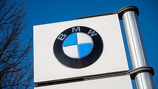 Ein Schild mit dem BMW-Logo steht vor einem der Werke des Autobauers.