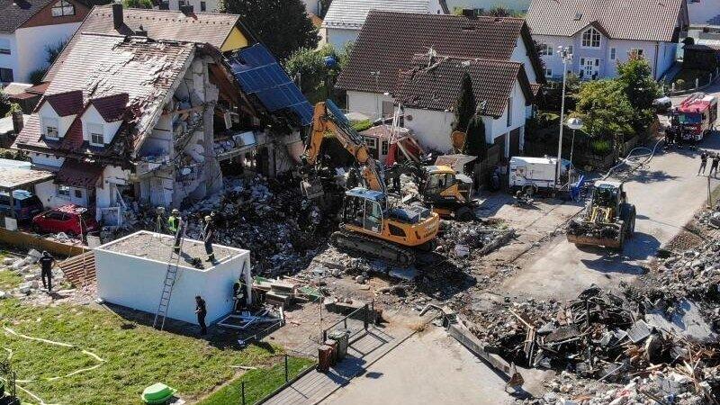 Zwei Bagger und ein Radlader sind bei Bergungsarbeiten an den &Uuml;berresten des Hauses im Einsatz.