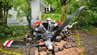 Ein Propeller der Maschine liegt vor einem Wohnhaus.