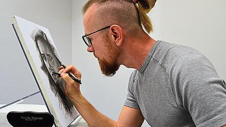 Heiko Juranowitsch beim Zeichnen und damit verbundenem Wegradieren.