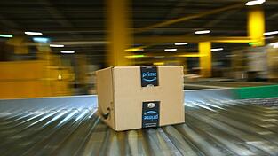 Ein Paket auf dem Laufband eines Amazon-Logistikzentrums - auf Prime-Kunden kommt eine Preiserhöhung zu.