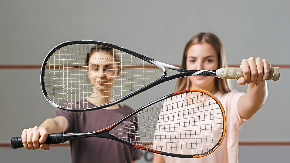 Zwei M&auml;dchen zeigen ihre Squash-Schl&auml;ger. Die Sportart ist etwas in Vergessenheit geraten, macht aber noch immer viel Spa&szlig;.