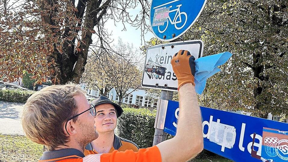 Vor Ort versuchen Bauhofleiter Michael Pokoj-Metag und Straßenwart Tobias Hartmann vergeblich die Aufkleber zu entfernen. Vor Ort versuchen Bauhofleiter Michael Pokoj-Metag und Straßenwart Tobias Hartmann vergeblich die Aufkleber zu entfernen.