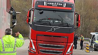 Ein Z&ouml;llner hilft, den Lastwagen f&uuml;r die Hightech-Kontrolle in Position zu bringen.