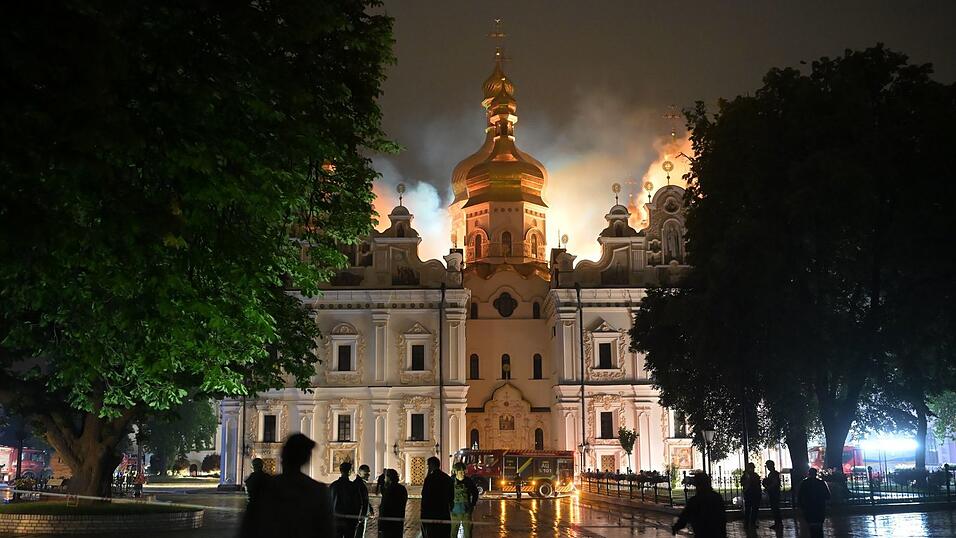 Flammen züngeln aus dem Dach unter den vergoldeten Kuppeln der Mariä-Entschlafens-Kathedrale. Flammen züngeln aus dem Dach unter den vergoldeten Kuppeln der Mariä-Entschlafens-Kathedrale.