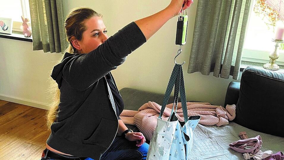 Die Hebamme Carolin Schießwohl wiegt ein Baby.