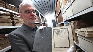 Memmingens Stadtarchivar Christoph Engelhard zeigt im Archiv eine Druckausgabe der «Zwölf Artikel» aus dem Jahr 1525. Mit dem Dokument forderten damals die Bauern mehr Rechte. Mit zahlreichen Veranstaltungen wird nun an die damalige Demokratiebewegung erinnert. (Archivbild)