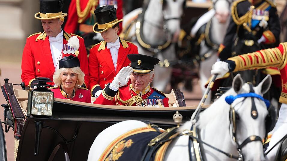 In einer offenen Kutsche fährt das britische Königspaar durch London. In einer offenen Kutsche fährt das britische Königspaar durch London.