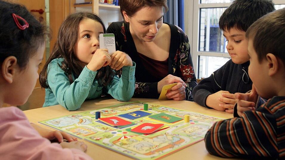 Kindergartenkinder spielen unter Aufsicht ein Sprachspiel. Kindergartenkinder spielen unter Aufsicht ein Sprachspiel.