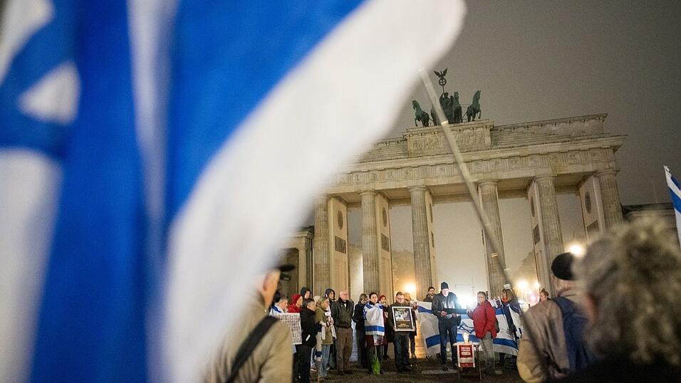 Menschen erinnern am Brandenburger Tor an die Opfer des 7. Oktober.