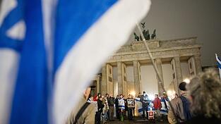 Menschen erinnern am Brandenburger Tor an die Opfer des 7. Oktober.