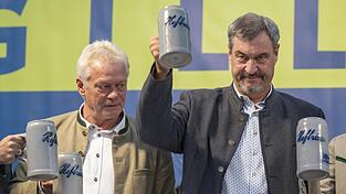 Markus Söder (r.) und Alois Rainer verteidigen auf dem Gilllamoos-Volksfest das Recht auf Fleischkonsum.