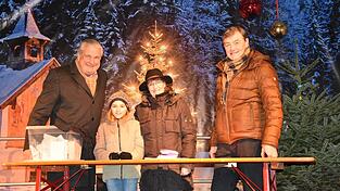 Im Rahmen des Christkindlmarktes wurden am Sonntagabend die Gewinner gezogen. Bernd Friebe (links) moderierte. Von der Heimatzeitung standen Georg Hagl und Monika Bichlmeier Gl&uuml;cksfee Anna-Lena zur Seite.