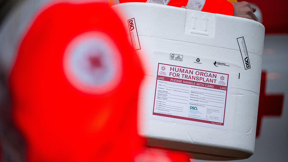 Mitarbeiter des DRK stehen mit einer K&uuml;hlbox f&uuml;r eine Organspende vor einem Transporter des Deutschen Roten Kreuzes.&nbsp;