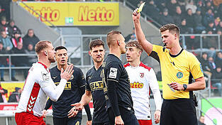 Einen unglücklichen Auftritt hatte aus Sicht der Jahn-Fans Schiedsrichter Yannick Sager. Hier zeigt der Referee allerdings Rostocks Franz Pfanne die gelbe Karte.