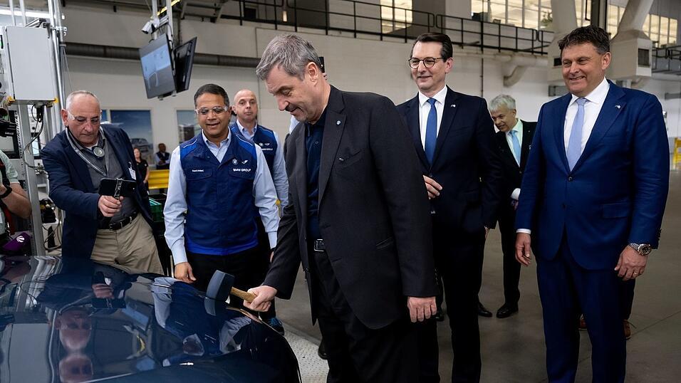 Bald f&auml;hrt ein BMW herum, dessen Logo auf der Motorhaube von Markus S&ouml;der per Hammer angebracht wurde.