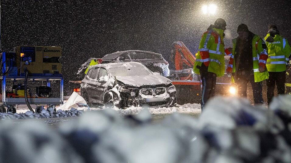 Auf der verschneiten Bundesstraße 12 stehen Feuerwehrmänner an einer Unfallstelle. Auf der verschneiten Bundesstraße 12 stehen Feuerwehrmänner an einer Unfallstelle.