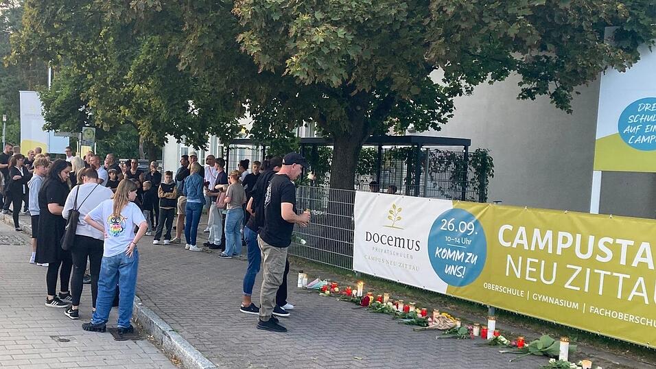Menschen gedenken der zwei Toten in Neu Zittau.
