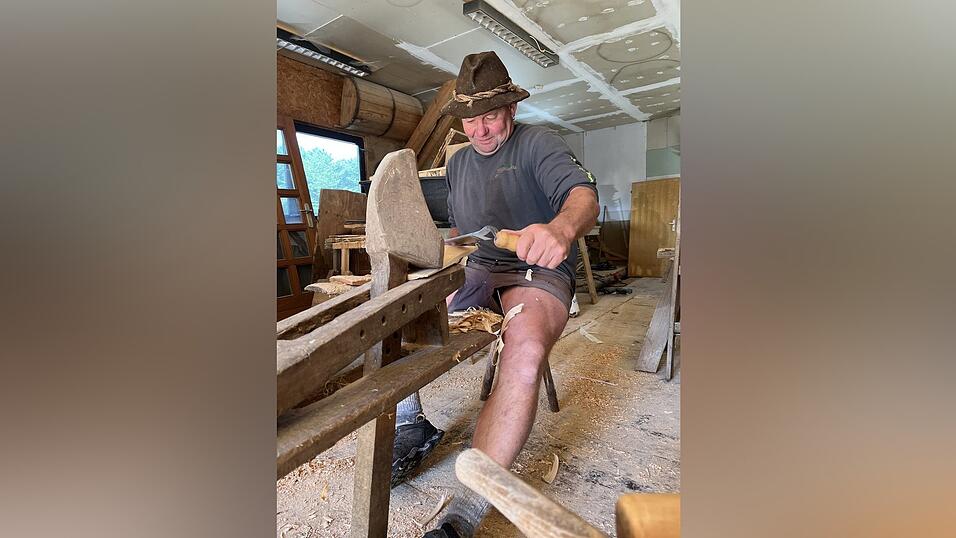 Stefan Müller ist einer von wenigen, die noch das Handwerk des Schindelmachens beherrschen. Hier sitzt er auf der Hoazlbank, darin werden Schindeln eingespannt, um sie mit dem Roafmesser bearbeiten zu können.