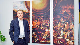 Prof. Dr. Joachim Nitschke in seinem Büro im BKH Straubing. Im Hintergrund ist das 'Inferno' zu sehen, ein Werk eines Schülers von Hieronymus Bosch. 