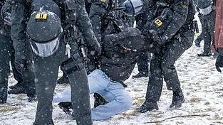 Polizisten ergreifen einen Teilnehmer einer Demonstration auf dem Königsplatz.