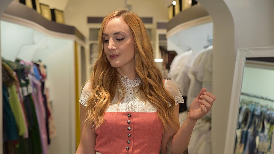 Auch dieses Dirndl trägt man am besten mit einer hochgeschlossenen Bluse. Die passenden Schuhe und eine Tasche runden den Look ab.