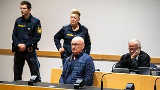 Der wegen der Ermordung von drei Nachbarn angeklagte Mann wird im Gerichtssaal von Polizisten bewacht. Der Mann will nach Angaben seines Anwalts auf Bildern nicht unkenntlich gemacht werden. (Archivfoto)