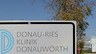 Vor der Donau-Ries Klinik weist ein Schild auf das Haus hin. Dort soll ein Narkosearzt mehrere Patienten mit Hepatitis-C infiziert haben. (Archivbild)