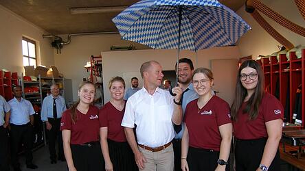 Daniel Weinberger &uuml;berreicht mit den Festdamen an B&uuml;rgermeister Thomas Etschmann einen Sonnenschirm.