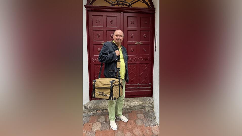 Georg Aigner vor seiner Haust&uuml;r in Landshut. Sein wichtigstes Accessoire auf Reisen: Die rund neun Kilo schwere K&uuml;hltasche, in der die Stammzellen transportiert werden.
