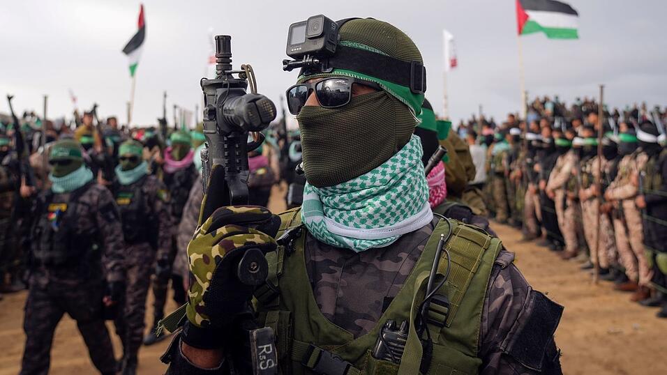 Vermummte Kämpfer der Hamas bei der Übergabe von vier toten Geiseln