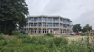 An der Fassade der Grundschule Nordwest werden gerade hölzerne Gestaltungselemente angebracht. Nach dem Verlegen des Estrichs beginnt der Innenausbau.
