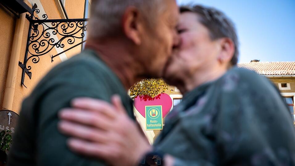 Ein Paar k&uuml;sst sich an der Eisenberger &laquo;Kusshaltestelle&raquo;.