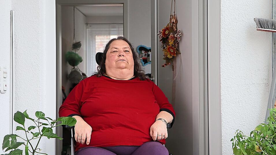 In der T&uuml;r von ihrer Wohnung sitzt Angelika Reschreiter in ihrem Rollstuhl. Wie lange sie noch dortbleiben kann, ist offen, denn ohne Pflegedienst kann sie nicht leben.