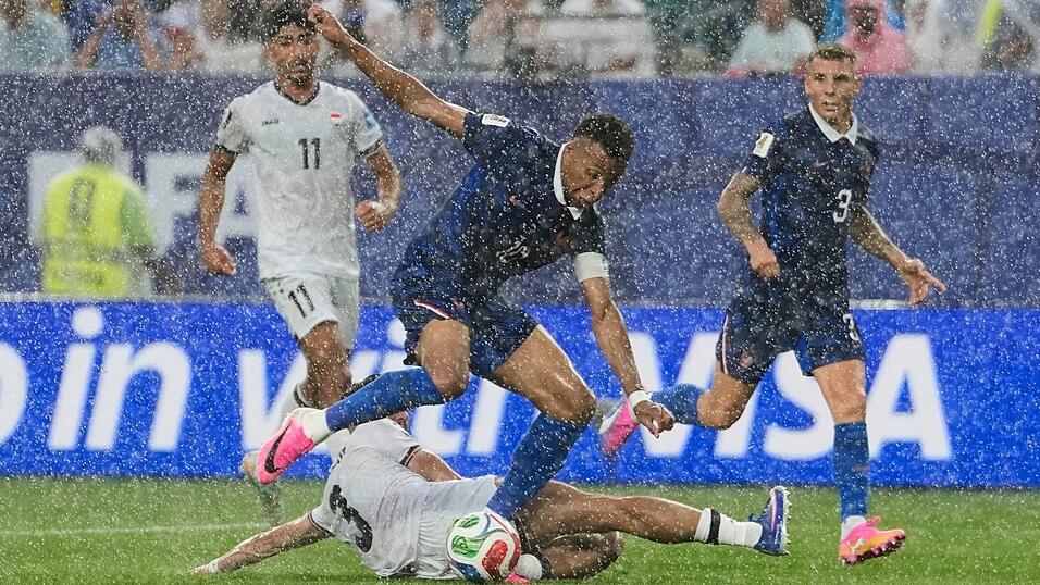 Stürmerstar im Regen: Frankreichs Kylian Mbappé im Zweikampf mit dem Iraker Hussein Ali. Stürmerstar im Regen: Frankreichs Kylian Mbappé im Zweikampf mit dem Iraker Hussein Ali.