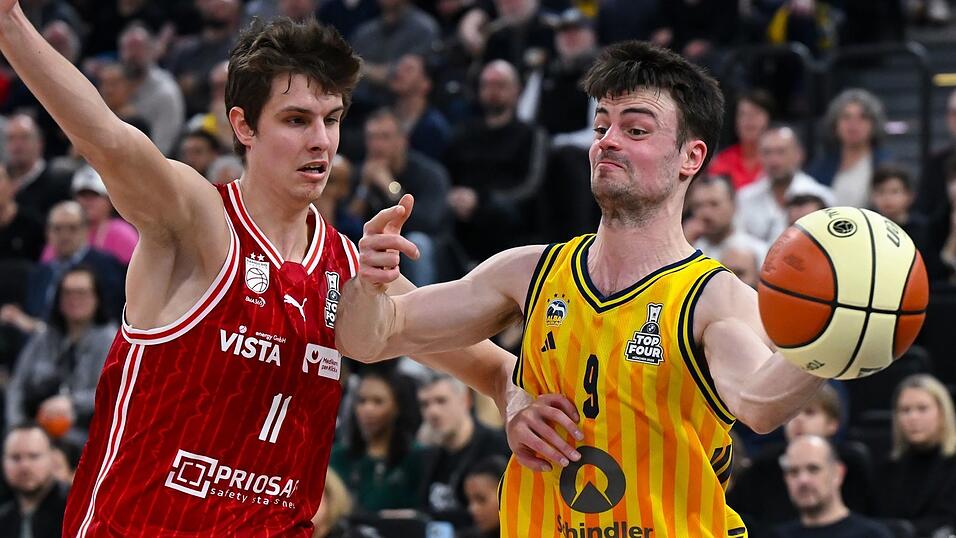 Bambergs Richard Balint (l) und Jonas Mattisseck von Alba Berlin k&auml;mpfen um den Ball.