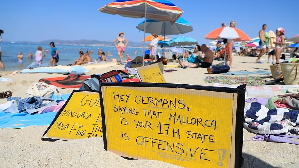 Deutsche Touristen, die sich im Urlaub allzu auftrumpfend benehmen, verursachen mitunter Widerstand - so wie hier auf Mallorca. (Archivbild) Deutsche Touristen, die sich im Urlaub allzu auftrumpfend benehmen, verursachen mitunter Widerstand - so wie hier auf Mallorca. (Archivbild)