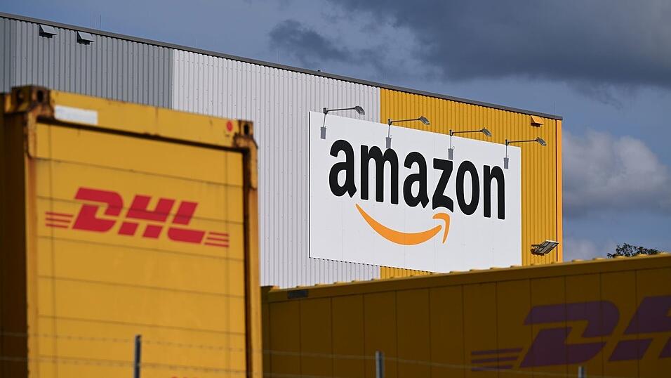 Ein Logistikzentrum von Amazon, auf dessen Gelände DHL-Container stehen. DHL ist das größte Paketunternehmen in Deutschland, gefolgt von Amazon - der Online-Handelsriese trägt einen großen Teil bei ihm bestellten Waren selbst aus. (Archivbild) Ein Logistikzentrum von Amazon, auf dessen Gelände DHL-Container stehen. DHL ist das größte Paketunternehmen in Deutschland, gefolgt von Amazon - der Online-Handelsriese trägt einen großen Teil bei ihm bestellten Waren selbst aus. (Archivbild)