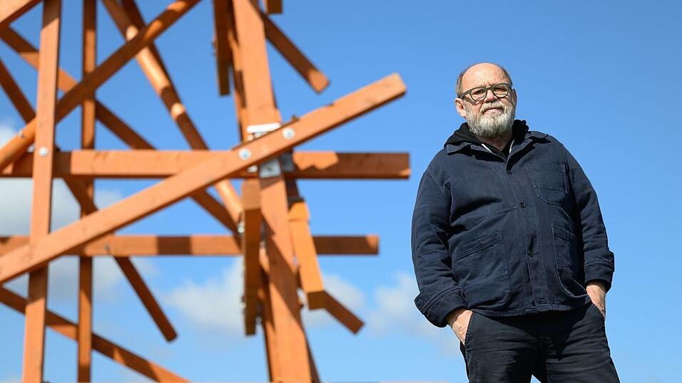 «Purple Path»-Kurator Alexander Ochs steht an der Arbeit «Zwei in einander Gewobene» des Konzeptkünstlers Olaf Holzapfel in Amtsberg. Das Gros der Kunstwerke an dem Kunst- und Skulpturenweg bleibt über das Jahr 2025 in der Region erhalten. (Archivbild)