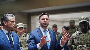 Verteidigungsminister Hegseth (l) und Vizepräsident Vance sprechen im Hauptbahnhof von Washington mit Mitgliedern der Nationalgarde.