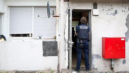 Ein Mitarbeiter vom Ordnungsamt der Stadt Duisburg steht im Eingangsbereich zu einem Wohnhaus, in dem eine Kontrollaktion gegen Sozialmissbrauch und Gesch&auml;ften mit Schrottimmobilien stattfindet.