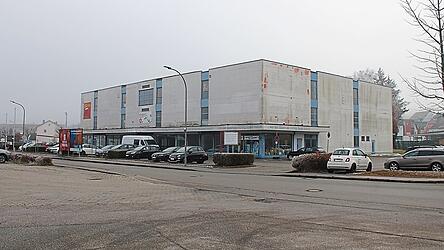 In diesem ehemaligen Möbelhaus soll nach den Plänen der Projektentwickler der BZ-Gruppe aus Kelheim durch eine Generalsanierung und Umnutzung ein Erweiterungsbau des Campus Dingolfing der Hochschule Landshut mit Hörsälen im Erdgeschoss sowie zahlreichen Kleinstwohnungen in den darüberliegenden Geschossen entstehen.