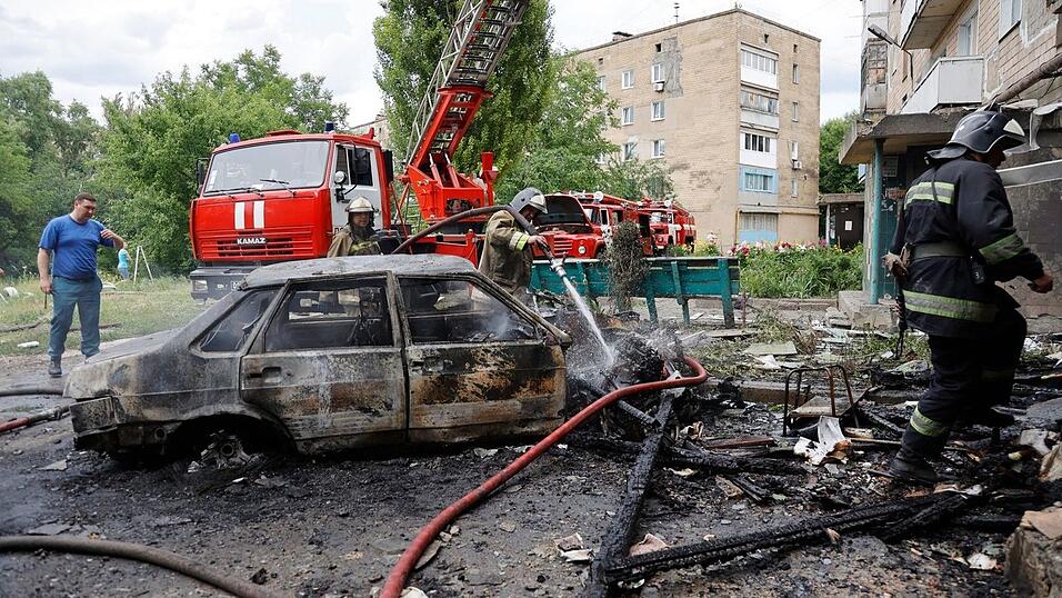 Feuerwehrleute löschen ein Wohnhaus und brennende Autos in Donezk im Osten der Ukraine, wo Separatisten von ukrainischem Beschuss berichten.