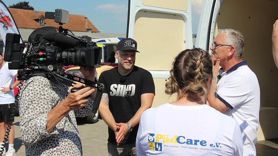 Mini-Volksfest in Straubing: Moderator Sidney Hoffmann (2.v.l.) bei der Übergabe des neuen Lieferwagens an Vertreter des Vereins PädCare e.V.